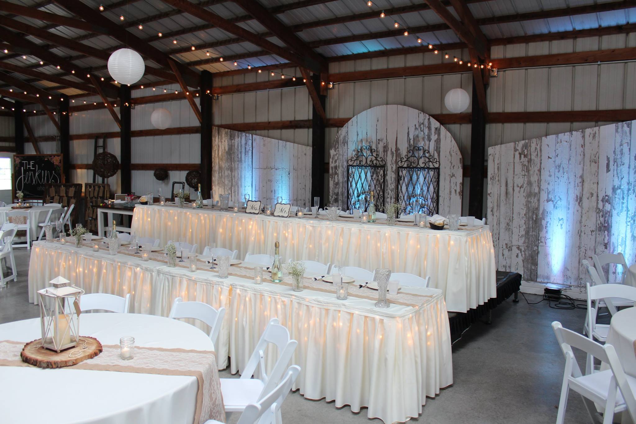 white linens and string lights on wedding party dining tables